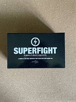 Top view of the Superfight game box, black with white logo and title