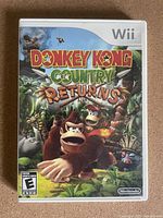 Front cover of Donkey Kong Country Returns Nintendo Wii game showing colorful jungle scene with Donkey Kong characters.