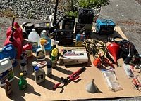 Wide view of jacks, battery, fluids, funnels and assorted tools on cardboard