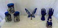 Group shot showing all blue glass items: 3 steins, 2 ring holders, soap dispenser, stained glass butterfly