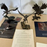 All three bronze bird sculptures with paperwork visible