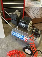 Overall view of Campbell Hausfeld air compressor with hoses attached