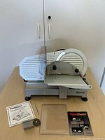 Full view of slicer with accessories and manual