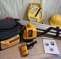 Overview showing L3 laser, carrying case, tripod, open-reel tape, hard hat, remote and manual