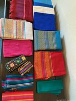 Overview of assorted folded textiles laid out on table