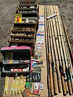 Overview of all tackle boxes, packaged accessories, rods and cue laid out on ground