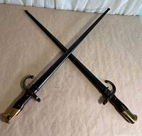Two crossed French bayonets with scabbards displayed full length