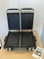 Grill opened showing dual cooking plates and manual