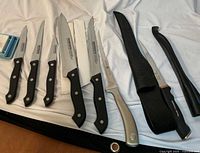 Overview of six knives, two sheaths and electric sharpener