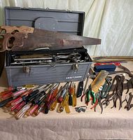 Overall lot view showing toolbox, saws, screwdrivers, pliers and other tools