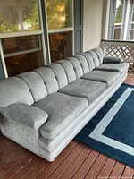Full view of extra long light blue sofa on porch