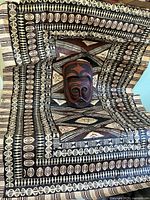 Painted tapa cloth with mask placed on it