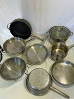 Overview of skillets, stock pot with insert, colanders and small steamer set