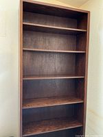 Full front view showing entire tall bookcase with shelves