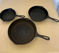 All three cast-iron pans top view showing sizes