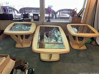 Front view of three matching wood tables with glass tops