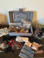 Overall lot with open storage box displaying assorted beads, sequins, trims and boxes