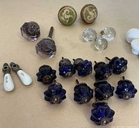 Group shot of purple glass knobs, green swirl knobs, clear glass ball knobs, cobalt blue cabinet knobs, porcelain levers
