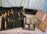 Overall view of all chisels in roll, metal box, wooden case and black case
