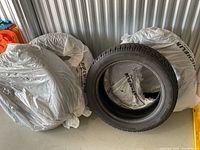 Overview of four winter tires with protective plastic bags