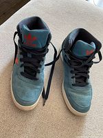 Pair of vintage Adidas running shoes showing front and top sides, teal suede with black laces and orange Adidas logo