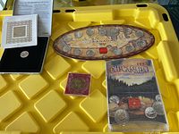 Overview of the coin collection showing a yellow background with an oval Canadian set, a black box with a coin, and other commemorative items.