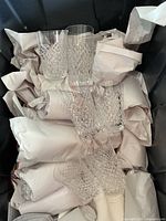 Nine cut crystal tumblers wrapped in packing paper