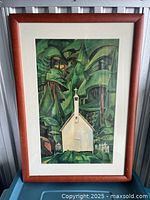 Front view of framed print showing a white church and green forest background