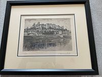 Full view of the framed print showing the castle scene with black frame and beige mat.