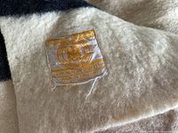 Close-up of the Hudson Bay label sewn onto the wool blanket showing brand information and origin in England.