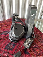 Frontal view of headphones, transmitter and adapter on table