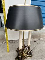 Front view of the lamp with black shade and measuring tape showing height approximately 24 inches.