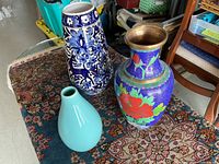 Three vases on a patterned rug showing size and design of each vase