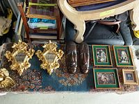 Various wall decor pieces including framed prints, decorative mirrors, African masks arranged on a rug
