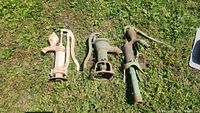 All three cast-iron hand pumps laid on grass for size comparison
