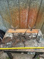 All thirteen ornate cast iron hooks displayed on workbench