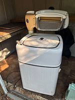 Full view of vintage wringer washing machine inside shed