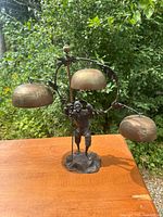 Full view of figural bell sculpture showing overall form and three bells