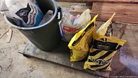 Overall lot: garbage bin with Sakrete bag, four additional bags on pallet including Windsor Safe-T-Salt