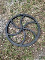 Full view of black cast wheel on gravel