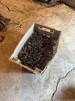 Full view of plastic crate on concrete floor holding coal pieces