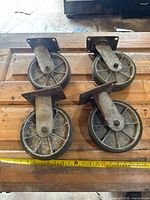 Top view of four swivel casters on wooden surface