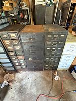 Front view of four metal filing cabinets showing drawer configuration and wear