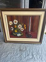 Overall view of framed floral still life painting showing subject, frame, and mat