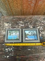 Both framed paintings side by side with measuring tape