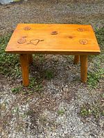Full view of wooden bench showing top, legs, outdoor setting
