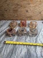 Top view of six square glass inkwells with measuring tape for scale
