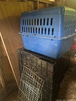 Overview showing blue plastic carrier on top of black wire cage