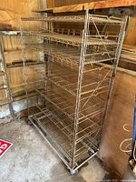 Full view of metal wire shelving rack with six shelves and casters