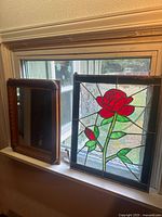 Mirror and stained glass panel on window ledge